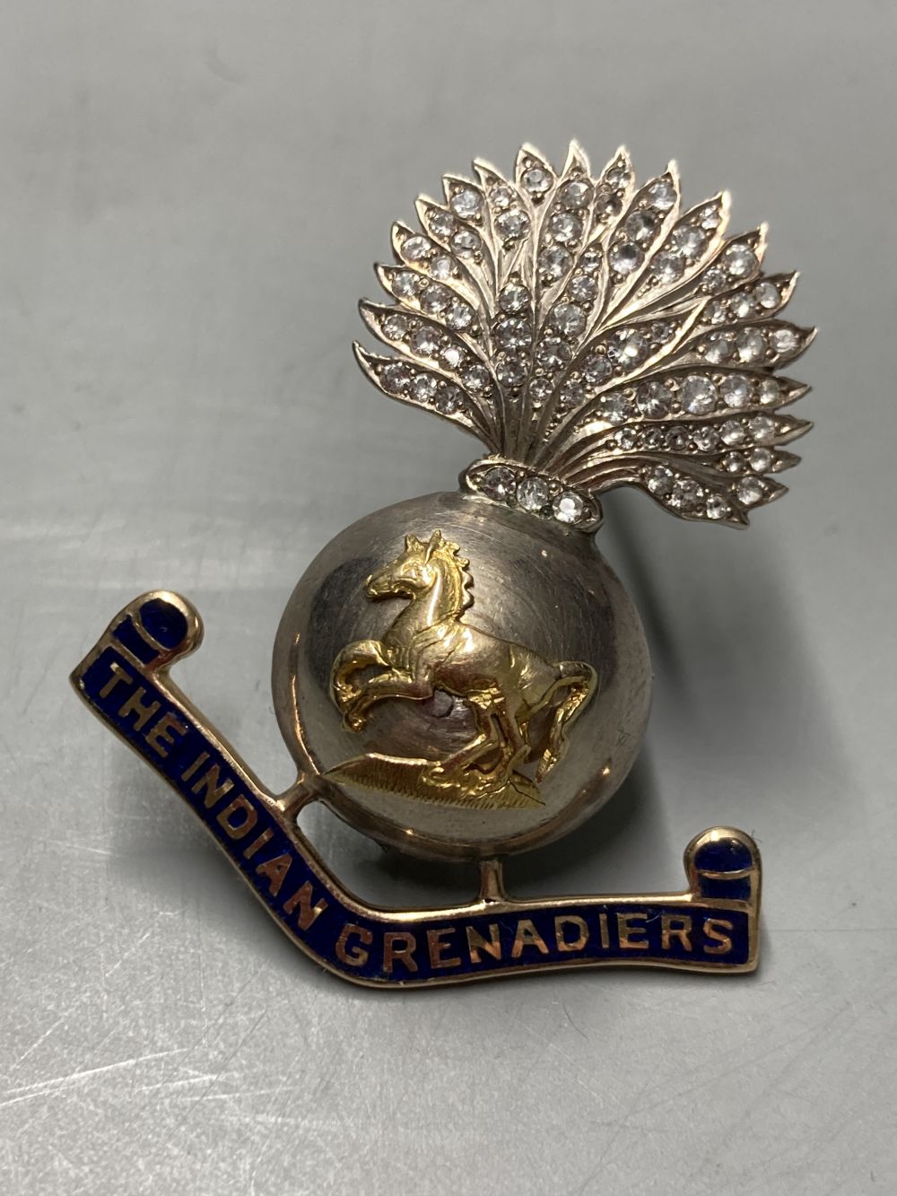 A paste and enamel set yellow and white metal The Indian Grenadiers brooch, 44mm.